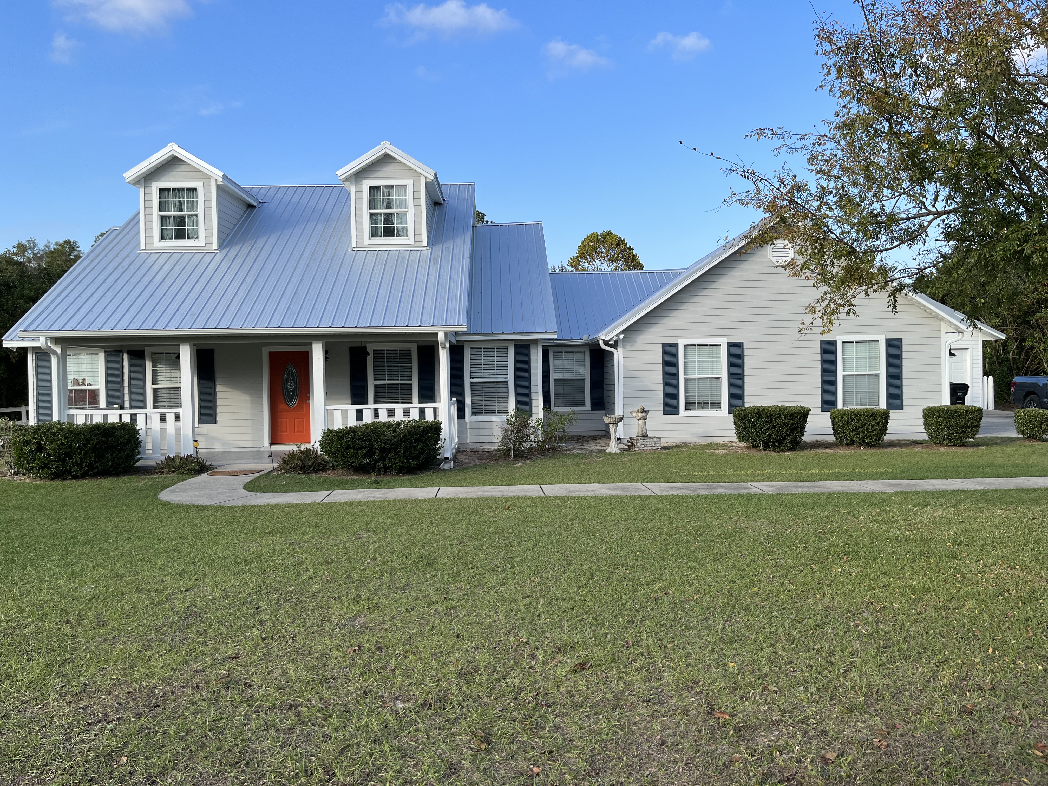 Farmhouse exterior painting gray with navy shutters by HPC in St. Augustine Florida
