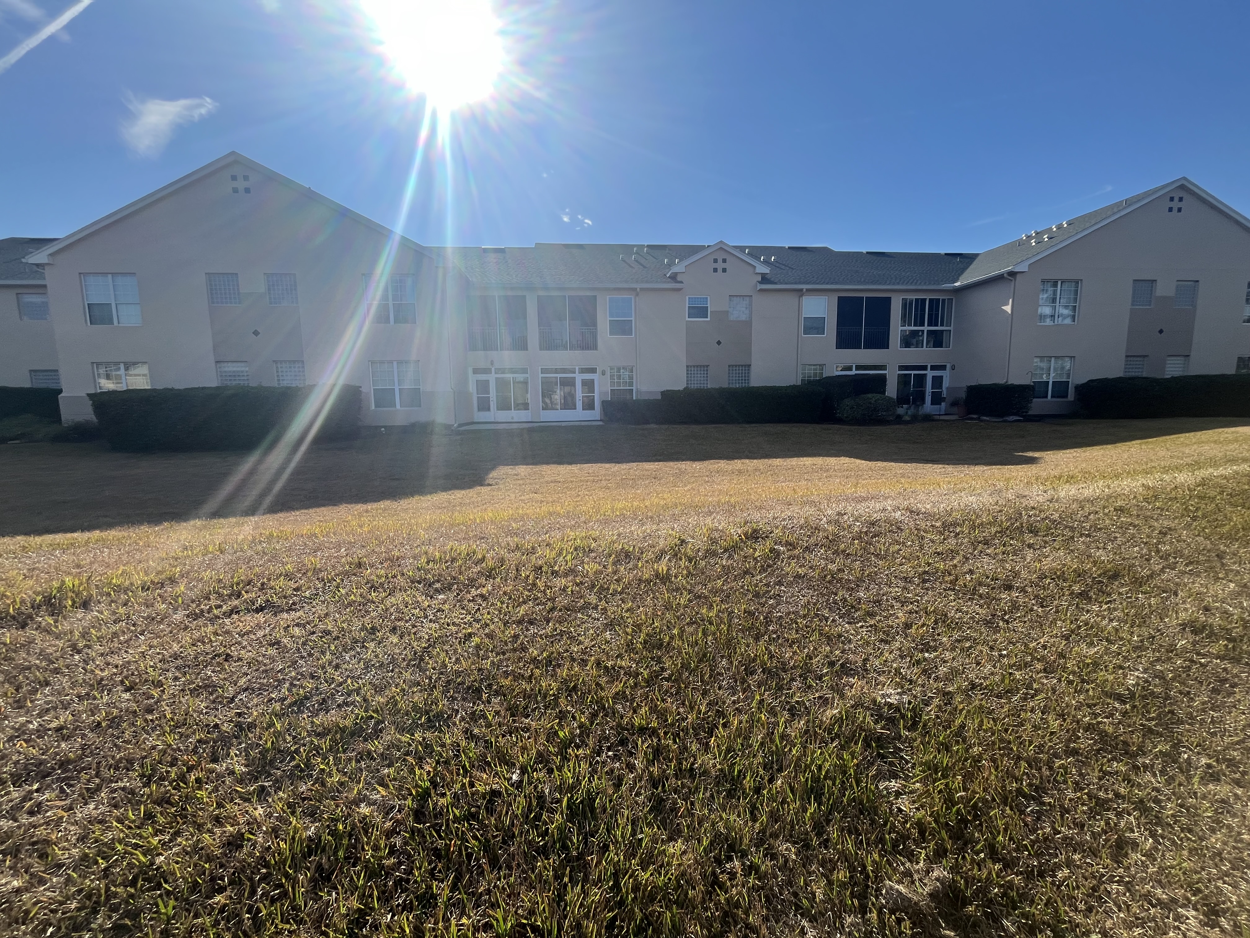 Apartment complex exterior painting side angle tan stucco by HPC Florida