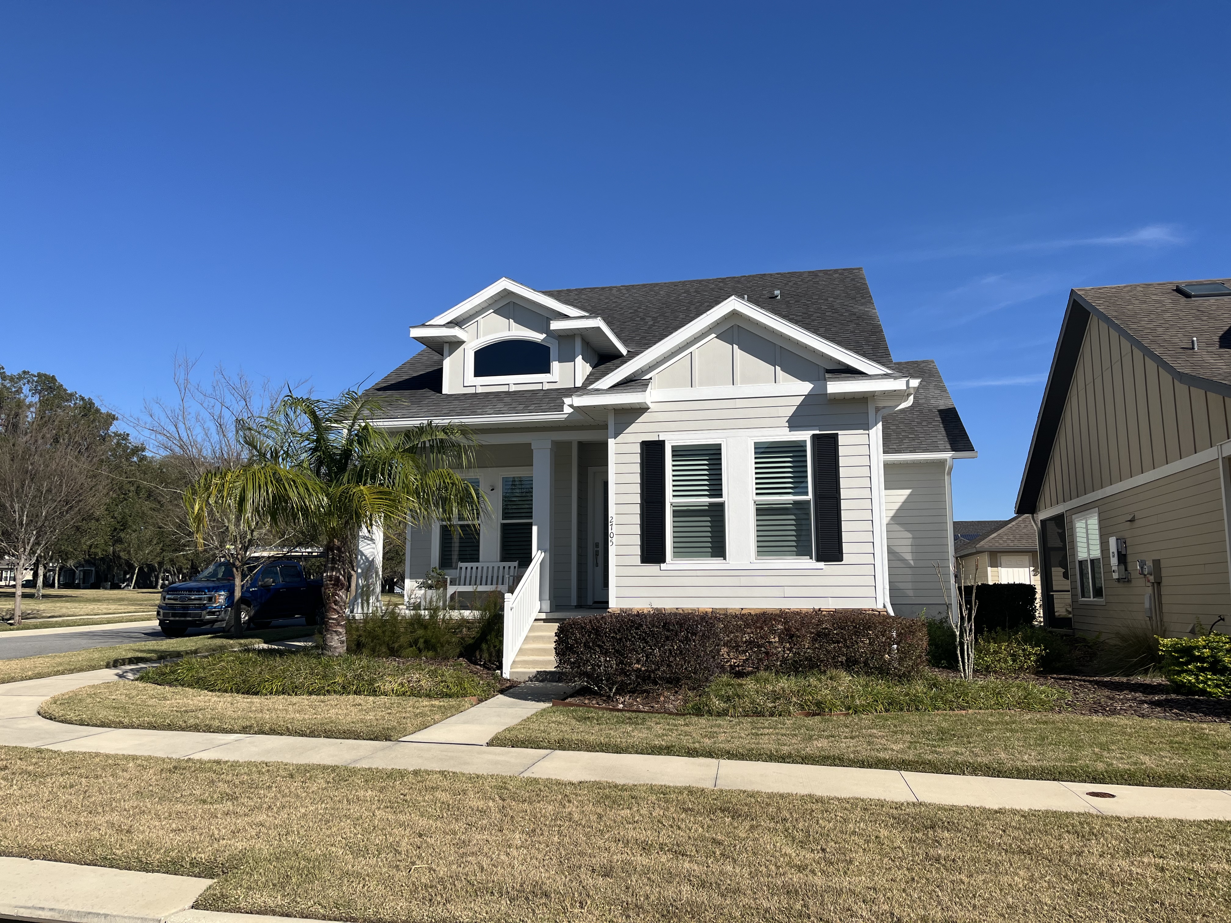 Craftsman home exterior painting gray siding black shutters by HPC in Ocala Florida