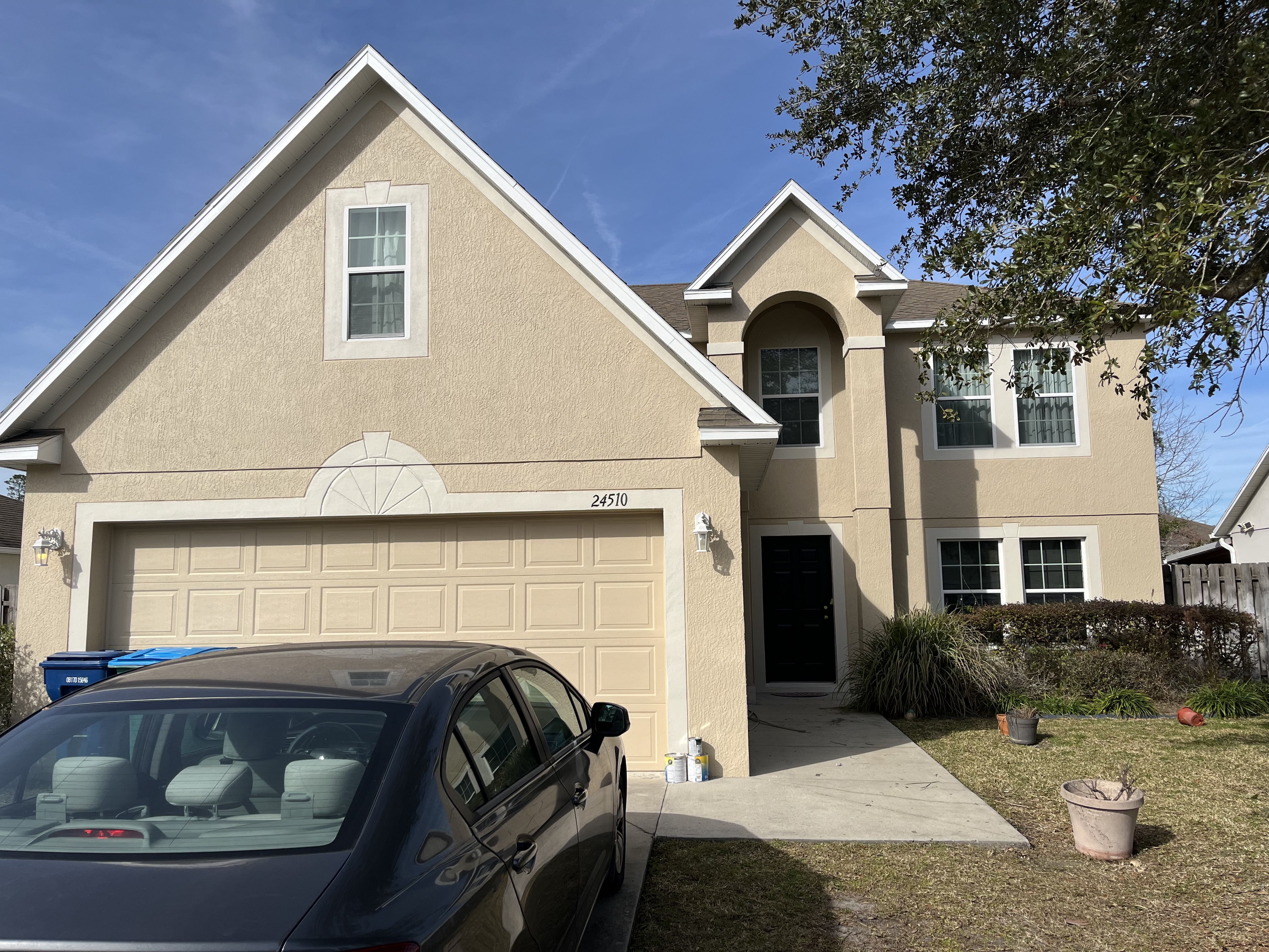 Two story stucco home exterior painting tan finish by HPC in Jacksonville Florida