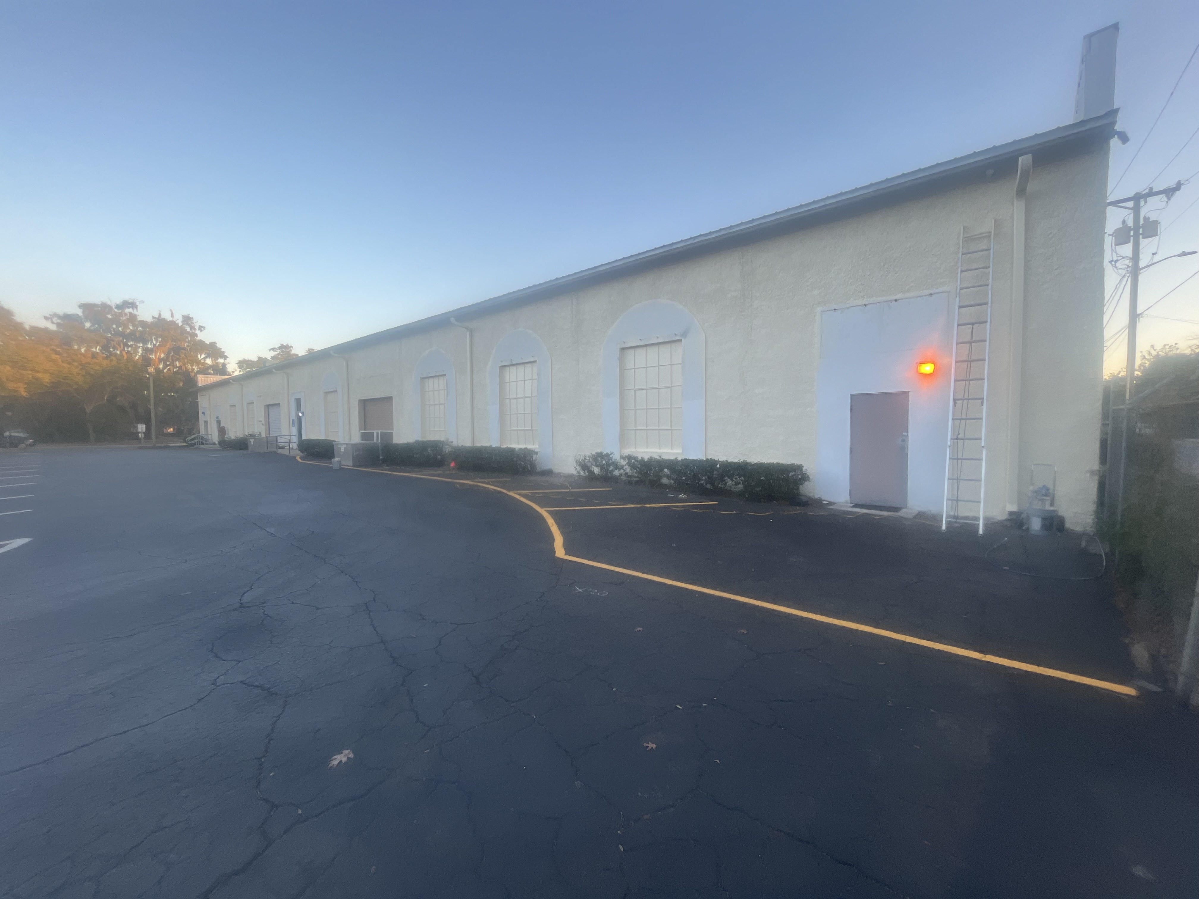 Commercial warehouse exterior painting white stucco by HPC Florida